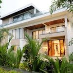A modern luxury villa surrounded by lush greenery, showcasing contemporary architectural design.