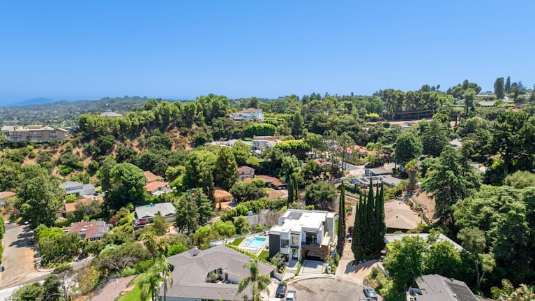 Stunning aerial view of a luxurious residential neighborhood surrounded by greenery.