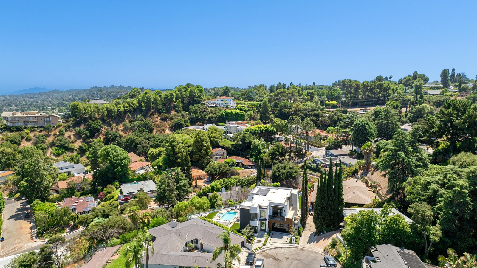 Stunning aerial view of a luxurious residential neighborhood surrounded by greenery.